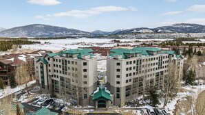 A multi-story hotel with a central courtyard, surrounded by snow-covered mountains. - Mountain Escape in Frisco | 2BR w/ Shared Hot Tub (Frisco)