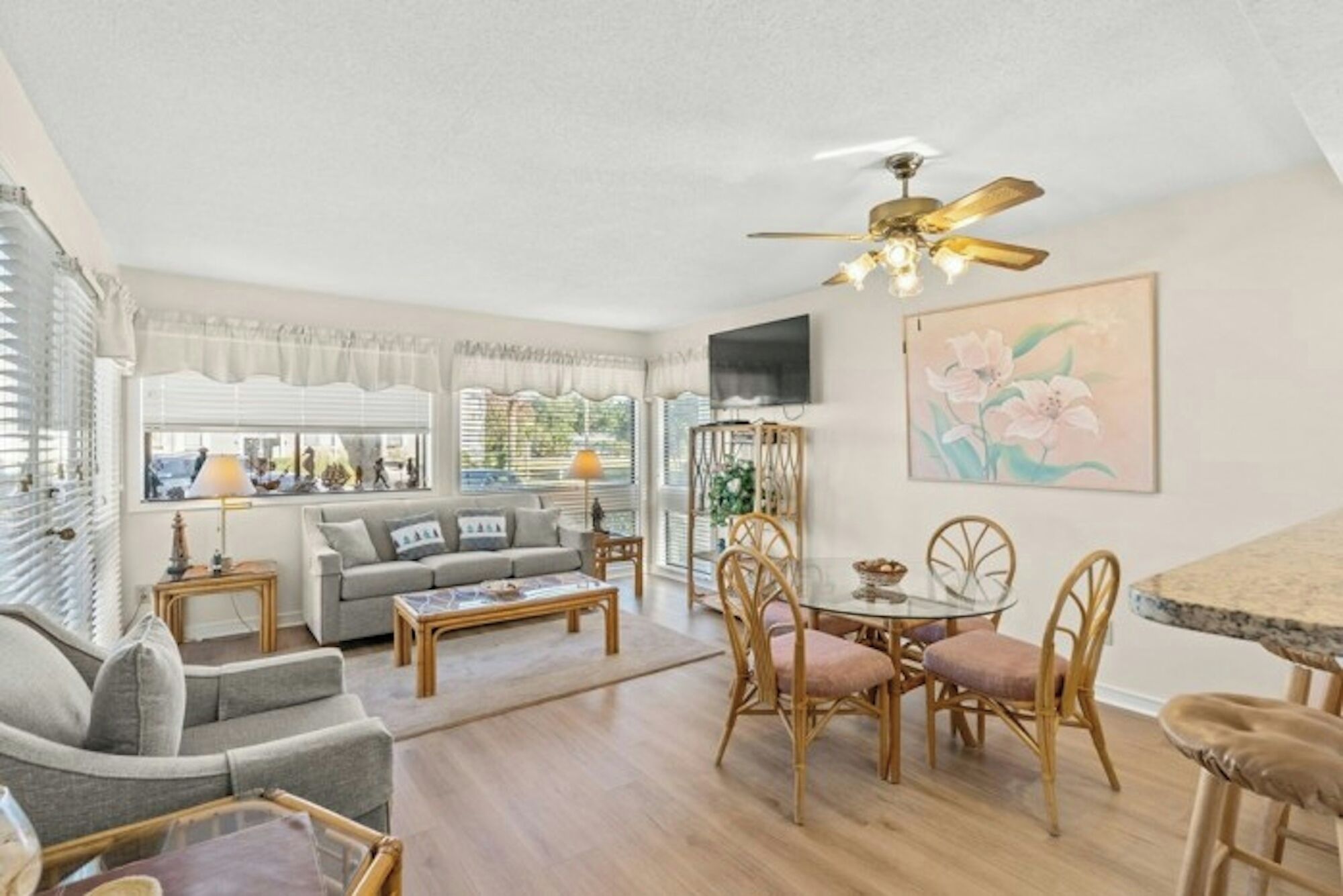 A spacious living area with a sofa, coffee table, dining table, and chairs.