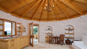 A rustic wooden interior with a stone floor, wooden cabinets, a chandelier, and a view through an open door. - Luxury Villa Azure Bay by the sea with heated pool and BBQ, perfect for families and pets (Bobovišća)