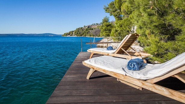 A wooden deck with lounge chairs and a view of the sea. - Luxury Villa Azure Bay by the sea with heated pool and BBQ, perfect for families and pets (Bobovišća)