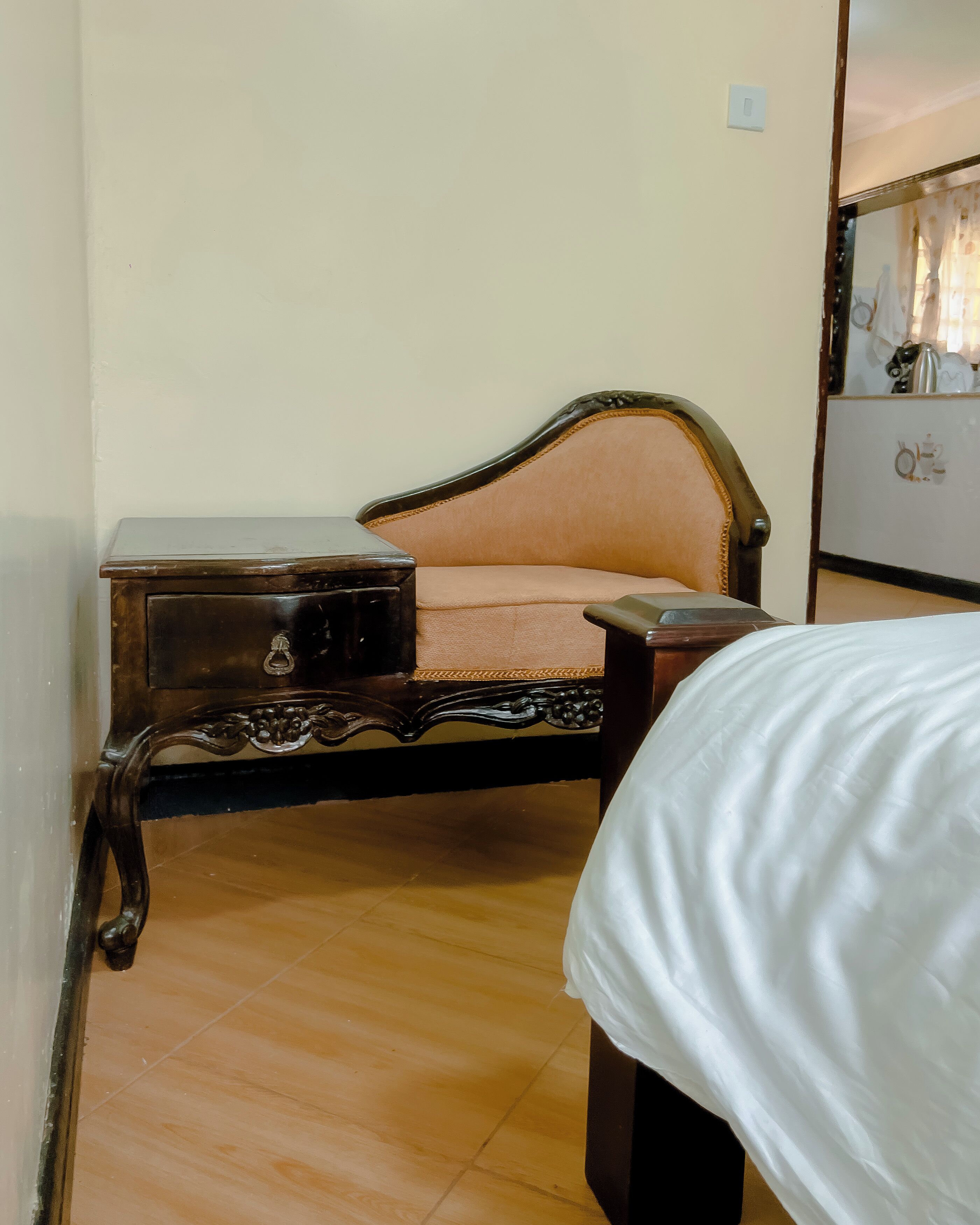 A room with a bed, a nightstand, and a chair.