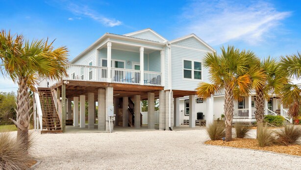 A two-story house with a covered porch, a staircase, and palm trees. - ☀️ Rhapsody in Blues - 2 Decks - Steps to the Beach - Pet Friendly 🌴 (Mexico Beach)