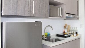 A kitchen with a stainless steel refrigerator, a sink, and cabinets. - Pure Simplicity: Sip Coffee Overlooking the Glittering City (Cebu City)