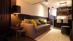 Un salon moderne avec un canapé, une lampe et un coin bar.