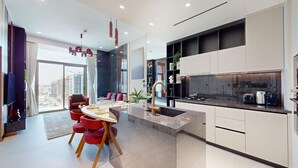 Una cucina moderna con isola centrale, elettrodomestici integrati e zona pranzo con sedie rosse.