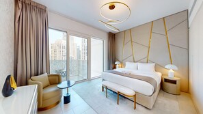 A modern hotel room with a large bed, a seating area, a balcony with a view of the city, and a unique ceiling light fixture. - Upgraded 1 Bedroom l JBR Beach l Private Beach (Dubai)