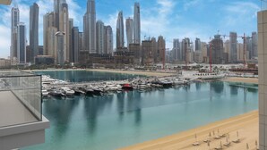Ein Yachthafen mit Booten, ein Strand und eine Stadtansicht mit hohen Gebäuden.