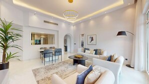 A modern living room with a sofa, coffee table, and dining area. - Chic 2 Bed l Sea Views l Palm Jumeirah Retreat (Palm Jumeirah)