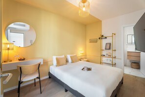 A hotel room with a bed, bedside table, chair, lamp, and a mirror. - Vandenbranden Suites (Brussels)