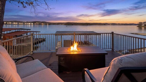 A deck with a fire feature, outdoor seating, and a view of a body of water. - Outdoor Dream Lakefront Home w/ Private Dock, 2 Slips & Kayak (Sunrise Beach)