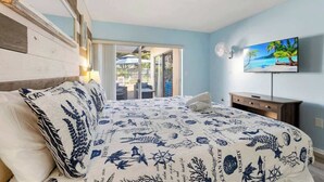 Un dormitorio con cama, televisión y vistas al exterior.