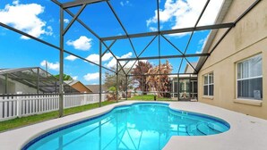 Una piscina con agua cristalina azul, rodeada por una cerca blanca y una estructura metálica en lo alto.