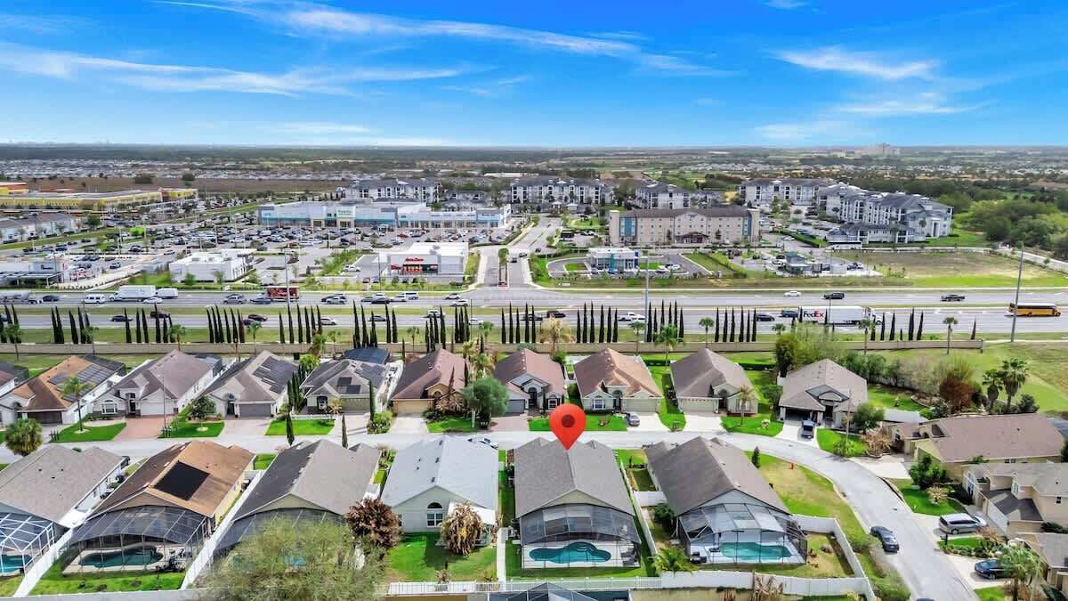 A residential area with houses, a road, and a large building in the background.