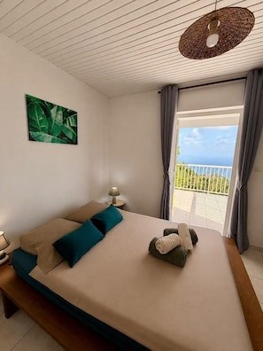 A bedroom with a bed, a bedside table, a lamp, a painting, and a balcony with a view. - 2-Bedroom. Stunning panoramic ocean view - Terraces & BBQ, Sainte-Luce (Sainte-Luce)