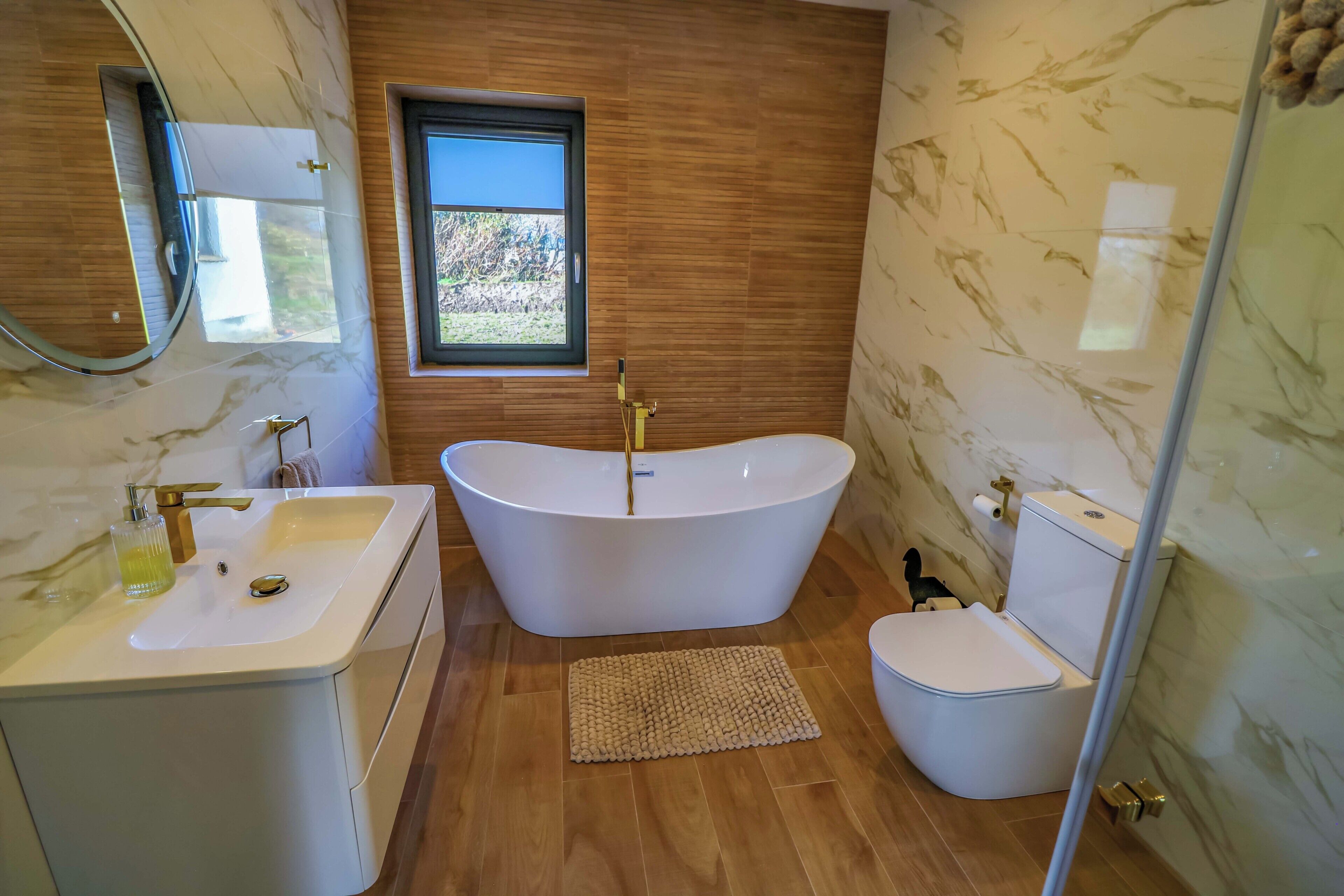 A bathroom with a freestanding bathtub, a sink, and a toilet.