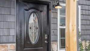 A black door with a decorative glass panel and a metal lock. - Cute Condo | Hot Tub | Minutes to Pigeon Forge! (Sevierville)