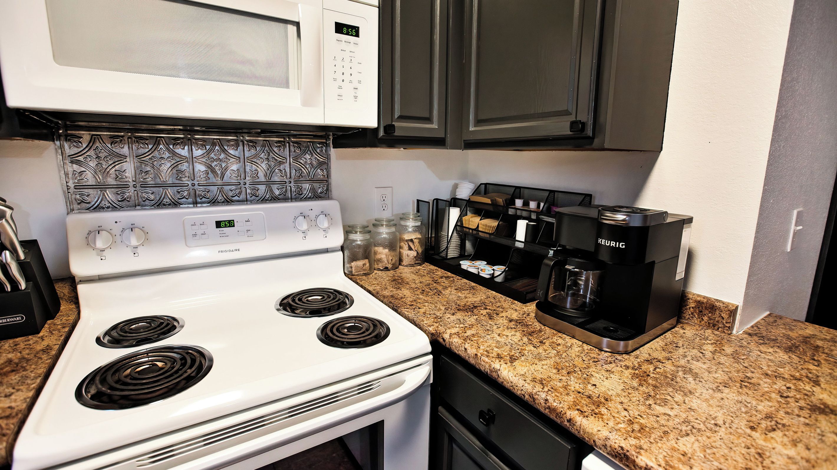 A kitchen with a white Frigidaire stove, a Keurig coffee maker, and a microwave.