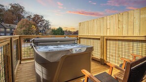 A hot tub on a wooden deck with a view of houses and trees. - Cute Condo | Hot Tub | Minutes to Pigeon Forge! (Sevierville)