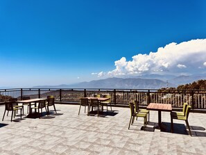 Um terraço com área de estar ao ar livre e vista panorâmica das montanhas.