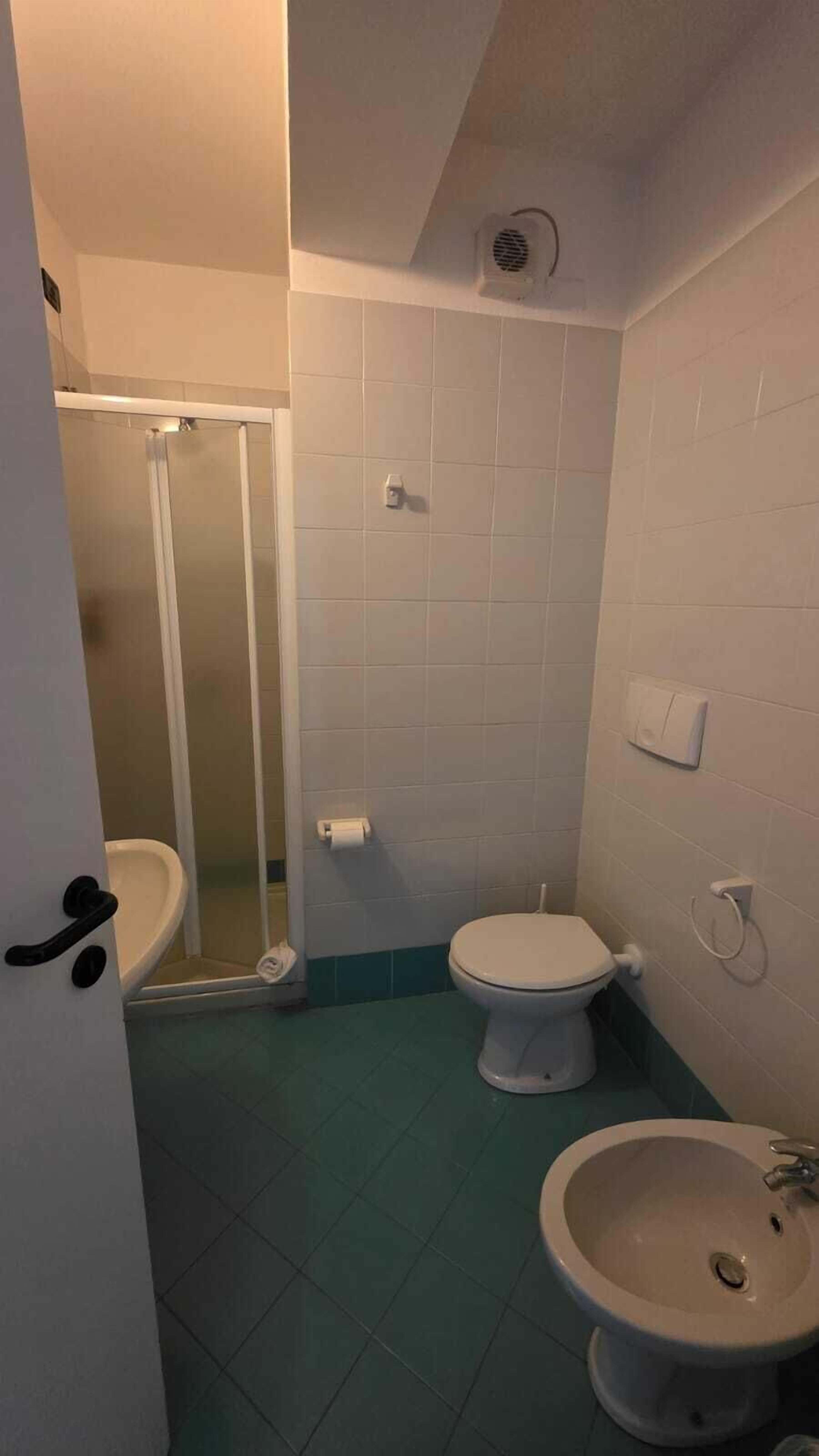 A bathroom with a shower, toilet, and sink.