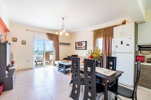 A dining area with a table, chairs, and a refrigerator.