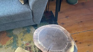 Een woonkamer met een bank, een salontafel, een bijzettafeltje en een kamerplant.