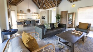 A spacious living area with a high ceiling, a dining area, and a kitchen. - Villa Riviersig,  a new stylish bushvilla (Hoedspruit)