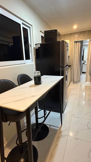 A kitchen with a marble countertop, a refrigerator, and a window. - Elegant Studio good for relaxing and work. (Sint Michiel)
