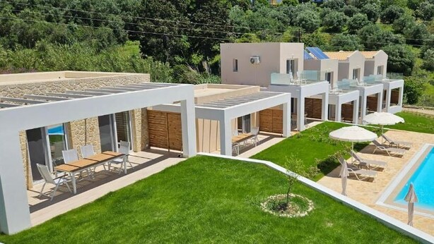 A modern villa with a swimming pool, outdoor seating, and a well-maintained lawn. - Arillas Peaceful Bungalows (Corfu)