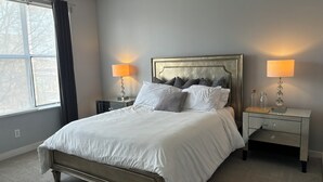 A bedroom with a bed, two bedside tables, a nightstand, a window with curtains, and a ceiling fan. - 4-Story Executive - Micro Suite - Private Rooftop - Free Parking (Atlanta)