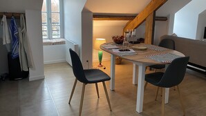 Un coin repas comprenant une table, des chaises, une lampe et une fenêtre.