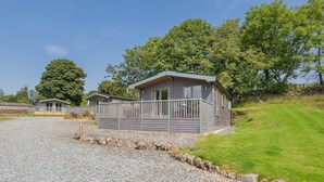 Un petit bâtiment d’un seul étage, doté d’un porche, entouré d’une allée en gravier et d’une pelouse.