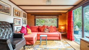 A cozy room with a leather sofa, a small table, and framed pictures on the wall.