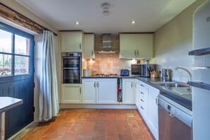A kitchen with white cabinets, a gas stove, a microwave, and a dishwasher. - The Dog House at Underley Estate - Kirkby Lonsdale (Kirkby Lonsdale)