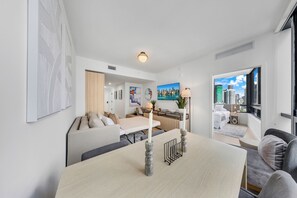 A modern living room with a dining area, a kitchen, and a bedroom. - District 225 (Miami)