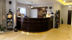 A reception area with a curved reception desk, a clock, and a sign that reads 'RECEPTION KARPACA & SPA.' - Karpacki&SPA z Restauracją  (Karpacz)