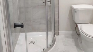 A bathroom with a glass-enclosed shower, a toilet, and a marble floor. - Fully Private Unit in Heart of Scarborough with Private Kitchen (Toronto)