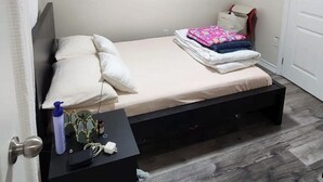 A small, neatly arranged bedroom with a bed, bedside table, and a door. - Fully Private Unit in Heart of Scarborough with Private Kitchen (Toronto)