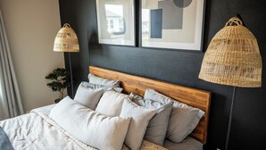 A bed with a wooden headboard, multiple pillows, and two woven lamps. - Stay in the Heart of Houston, 5' to Downtown, close Medical Center & World Cup (Houston)