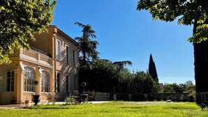 A building with large windows and a well-maintained lawn. - Sumptuous Manoir XIXᵉ between Aix & Cassis - Swimming pool, Garden & Sainte-Baume View (Auriol)