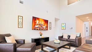 A living room with a fireplace, sofas, a coffee table, and a TV.
