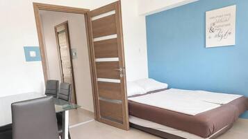 A room with a bed, a desk, and a chair.