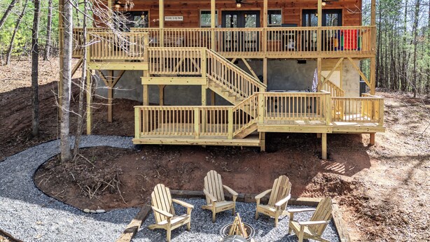 A wooden cabin with a porch, multiple decks, and outdoor seating. - Secluded Mountain Cabin with Hot Tub & Fire pit on 4 acres (Murphy)