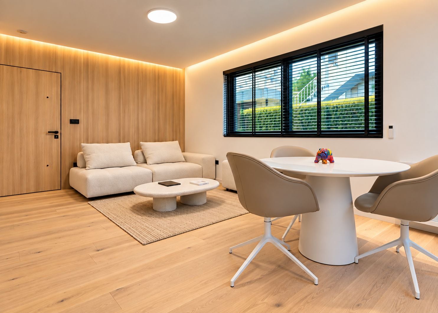 A modern living room with a sofa, a round table, and chairs.