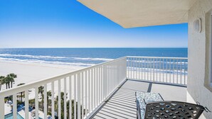 Ein Balkon mit Blick auf Strand und Meer.