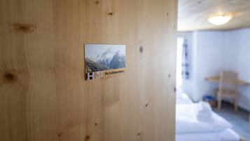 Eine Holzwand mit einem kleinen Schild, auf dem 'HM Piz Schalambert' steht.