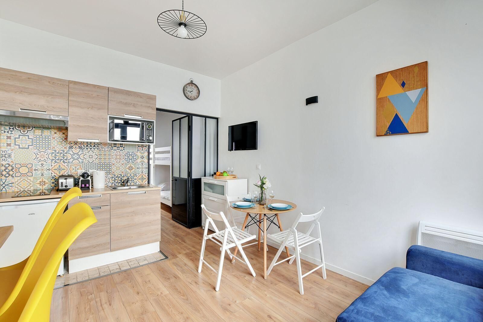 Un espace de vie compact comprenant un coin cuisine, un coin repas et un coin salon.
