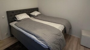 A room with a bed, two pillows, and a bedside table. - Business/couples - Parking - Wifi - Sleeps 3 (Jarfalla)
