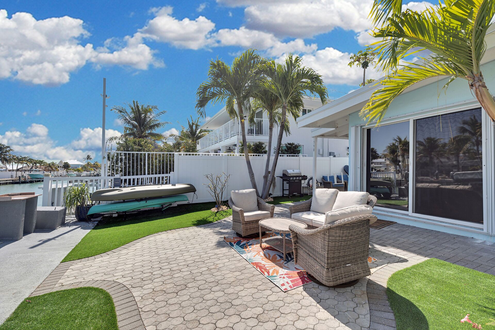 Une terrasse avec des meubles d’extérieur, un bateau et une vue sur l’eau.