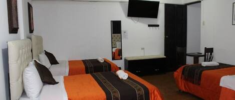 A hotel room with two beds, a TV, a desk, and a chair.